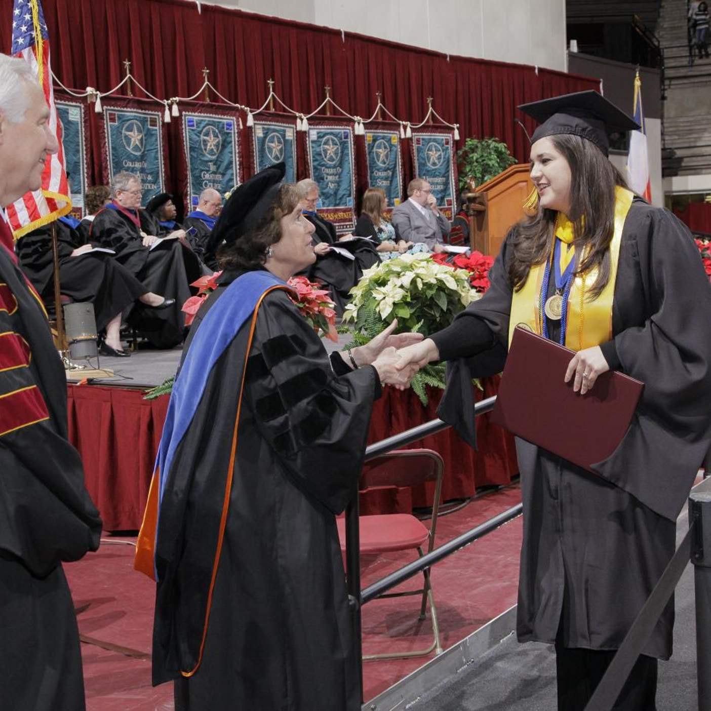 graduating candidate shakes hands with faculty 