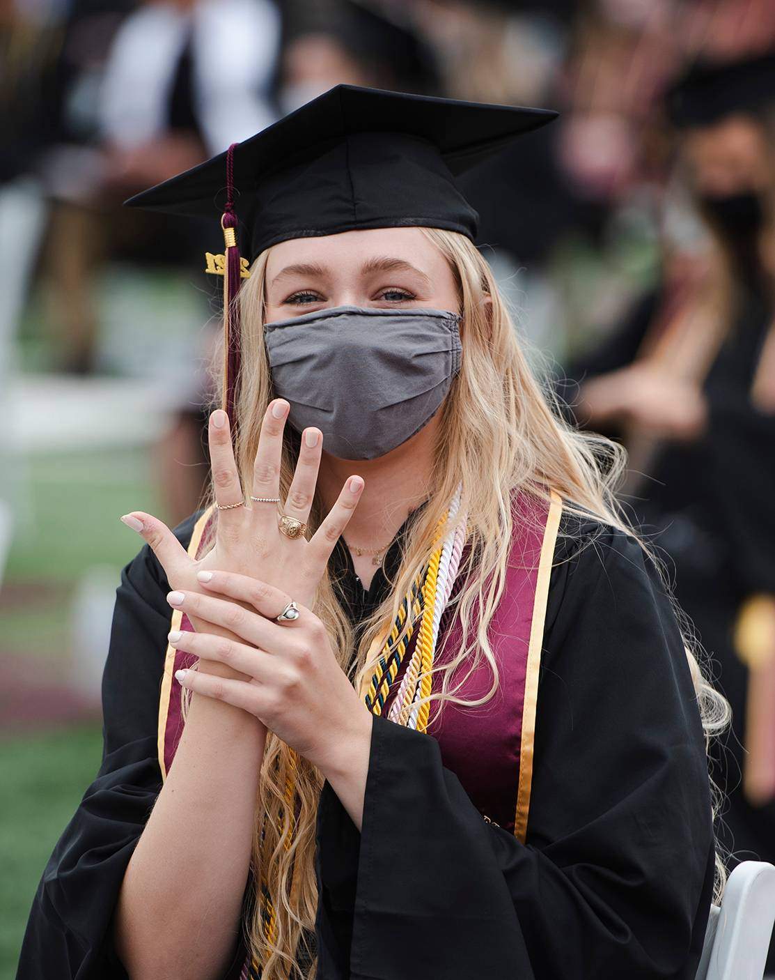 female graduate holding up hand showing off ring