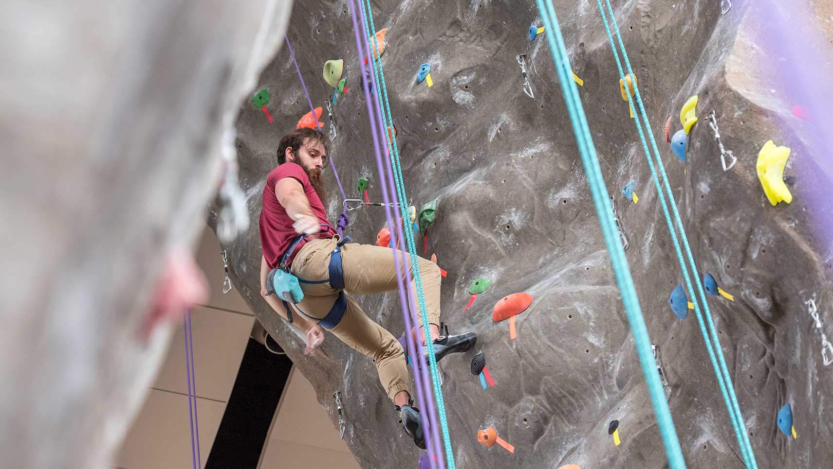 a male student climbs the rock wall