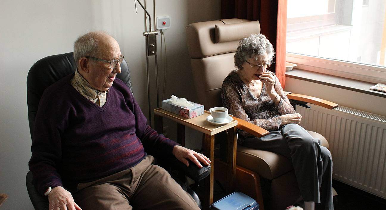 elderly couple sitting in home