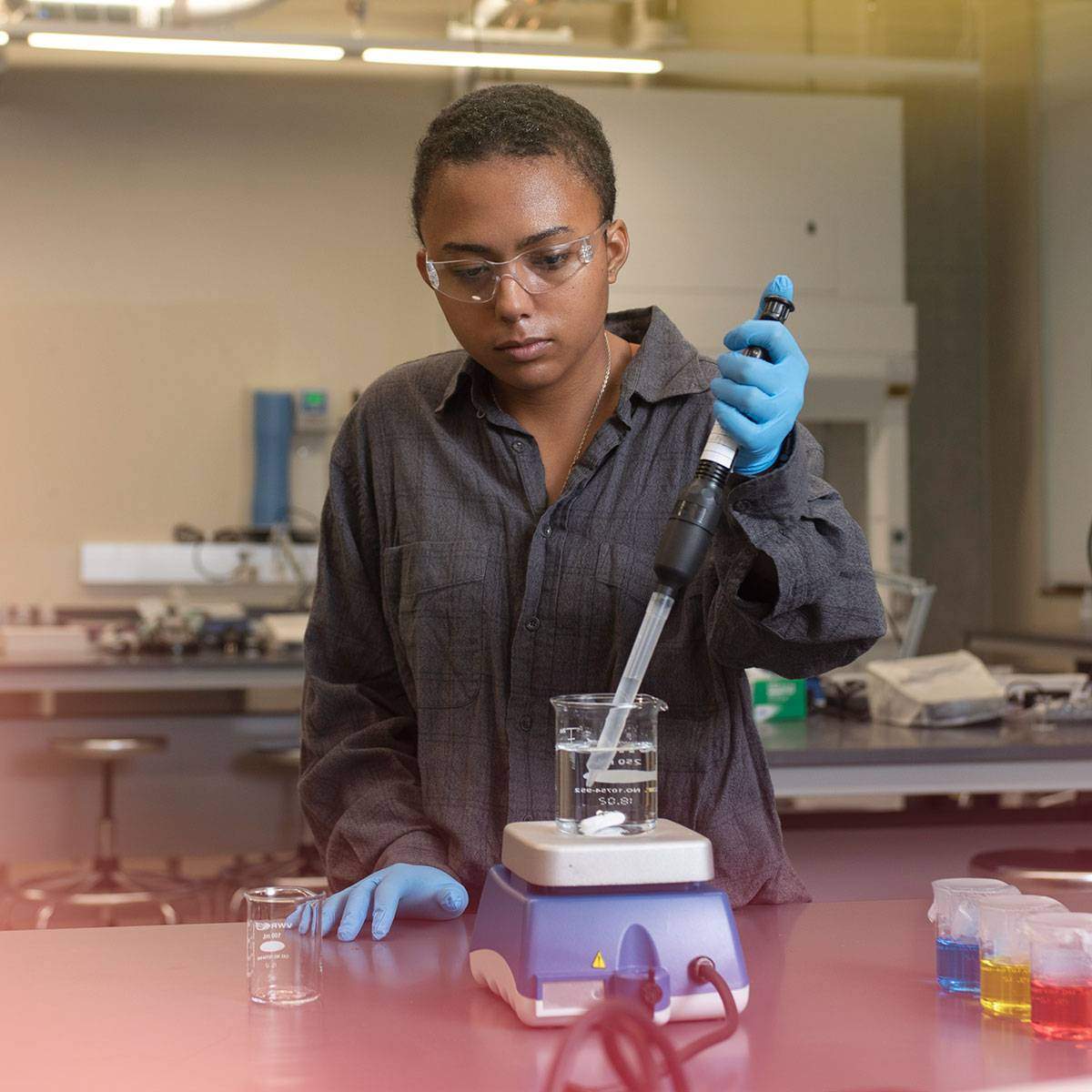 A student with close-cropped hair works in a science lab