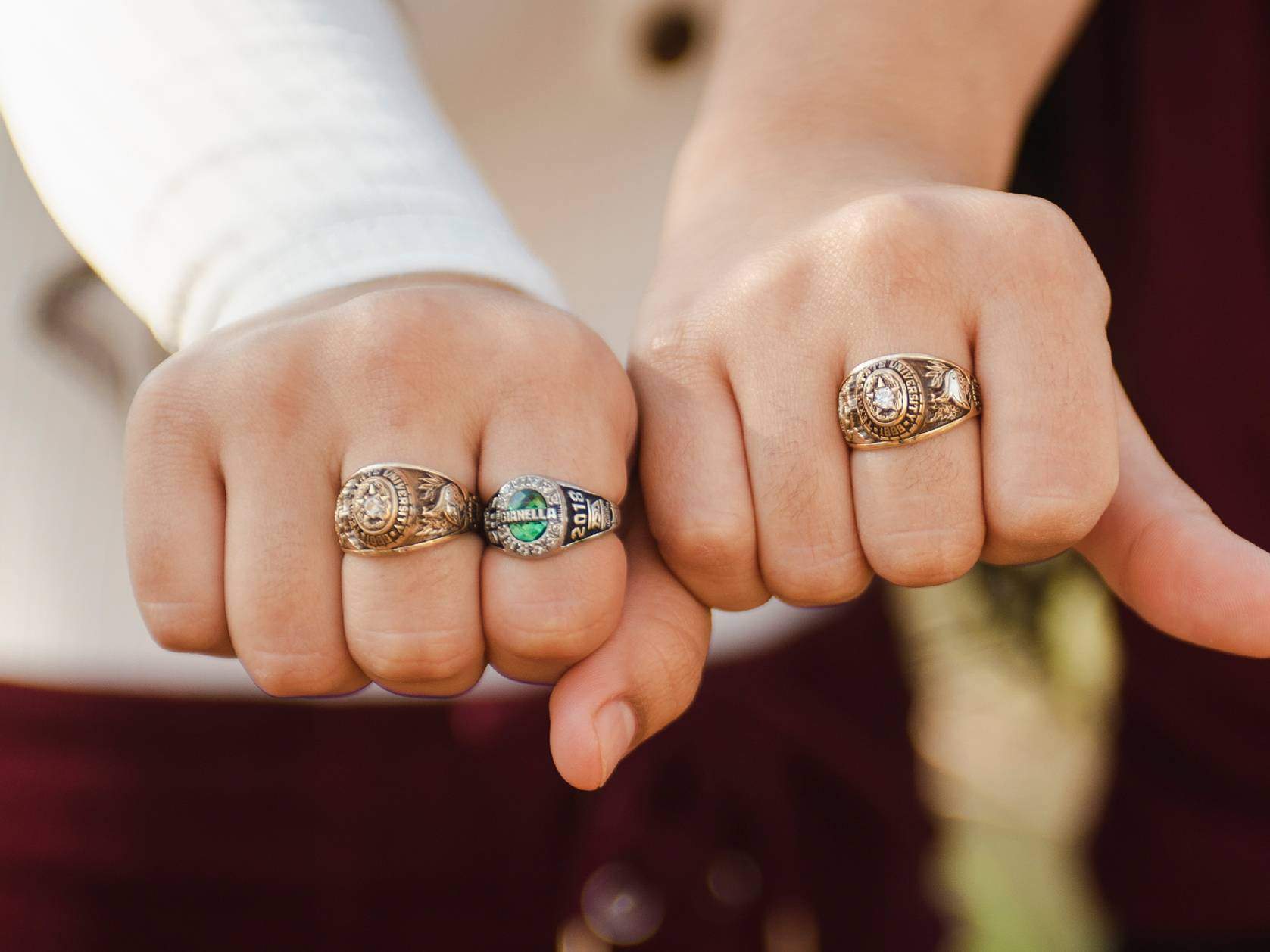 two hands with texas state class rings
