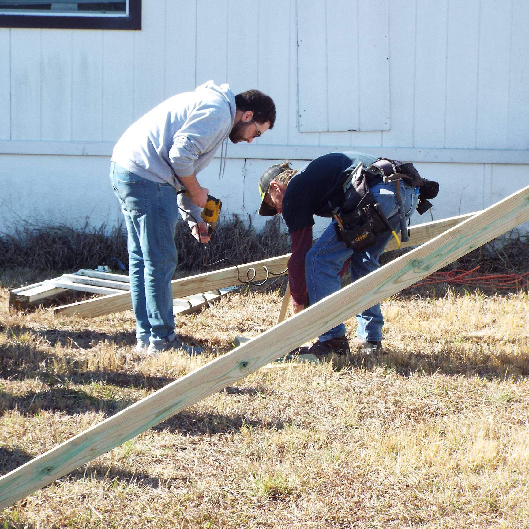 two people working on wheelchair ramp