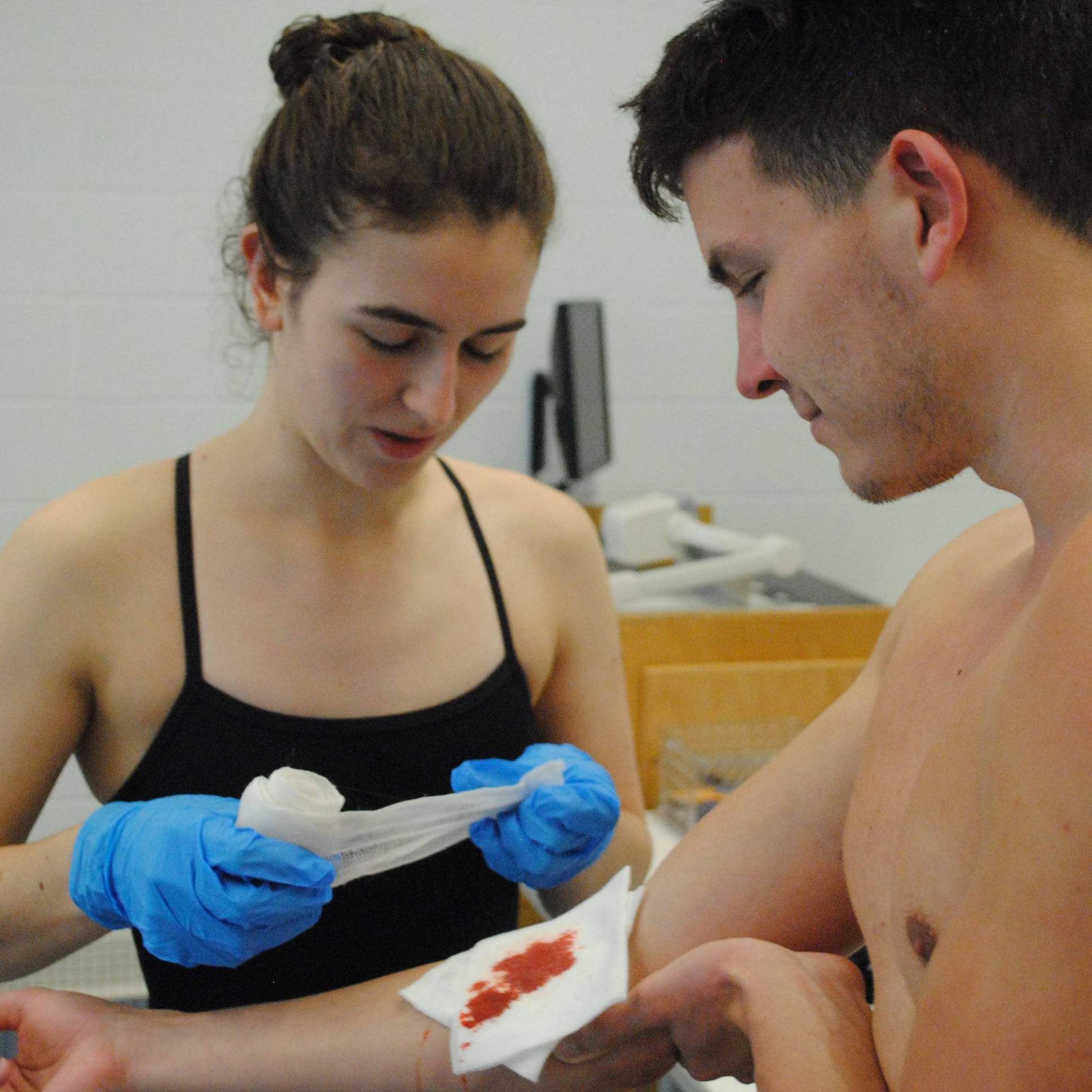lifeguard providing first aid for a cut on the forearm