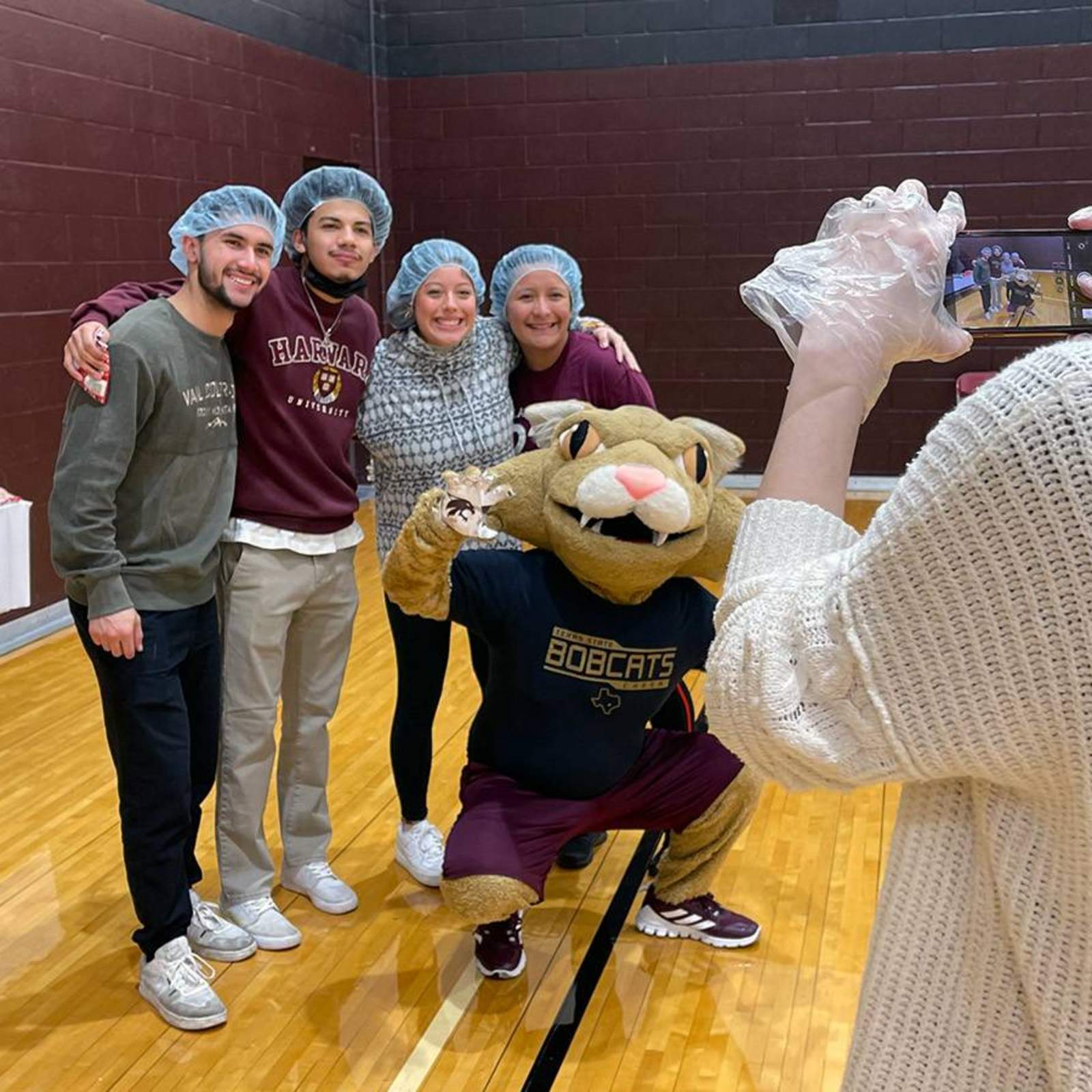 Students taking a photo with Boko, the Texas State mascot