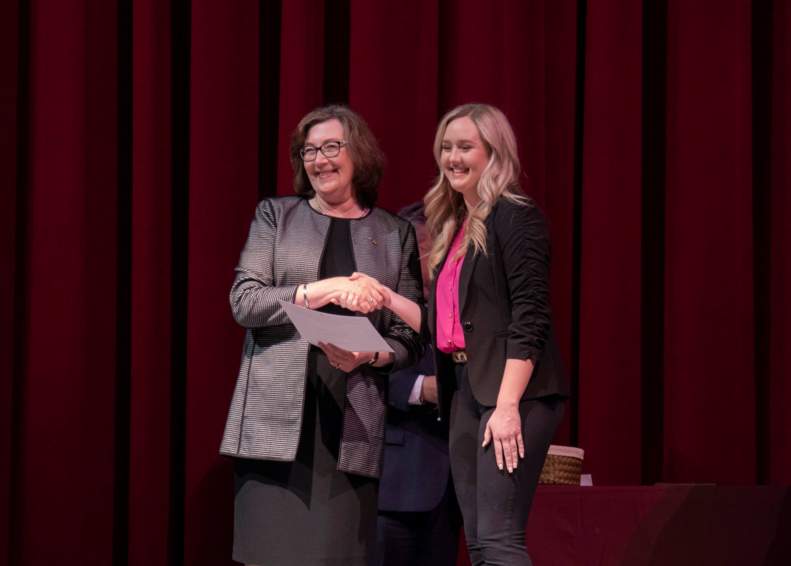DEan Smart awarding student with scholarship at annual awards day event