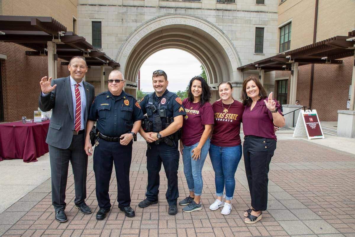 kelly and beth damphousse posing with police officers and upd staff