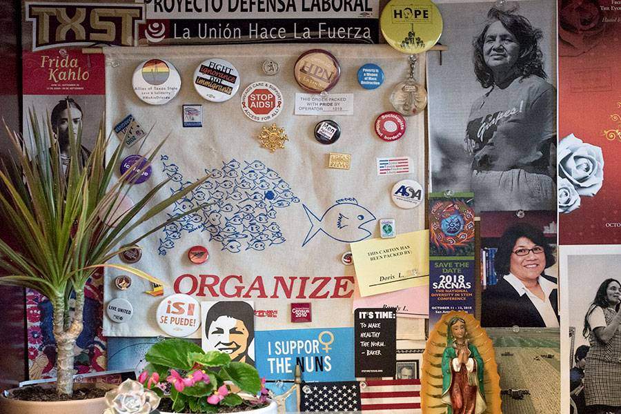 photographs, buttons and other items related to the Latinx community are pinned to the back of a desk for inspiration
