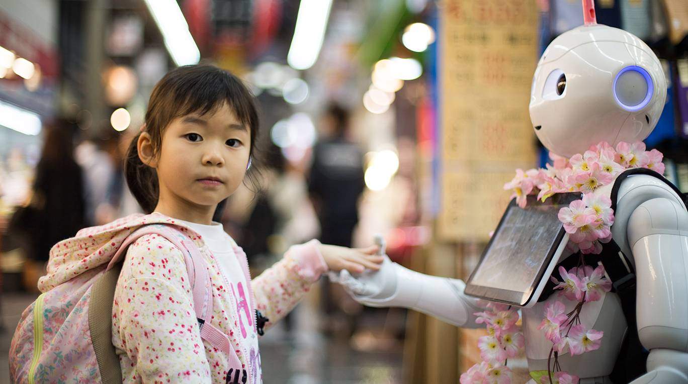 young japanese girl holding hand of robot
