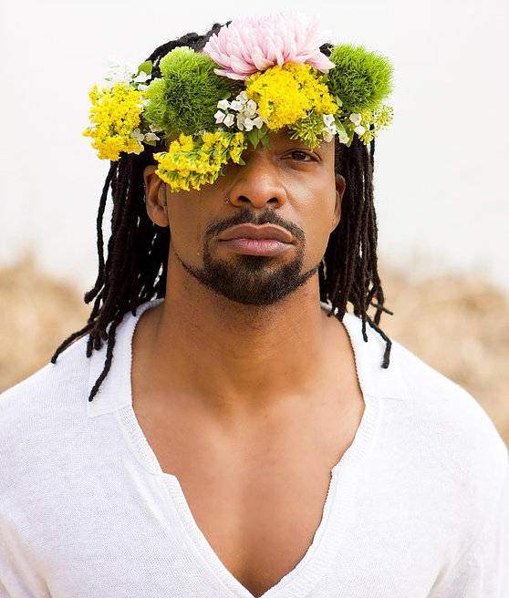 Jericho Brown wearing a crown made of flowers.