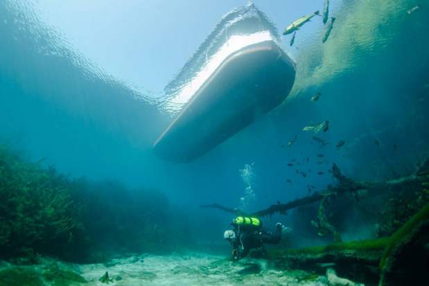 scuba diver under glass bottom boat