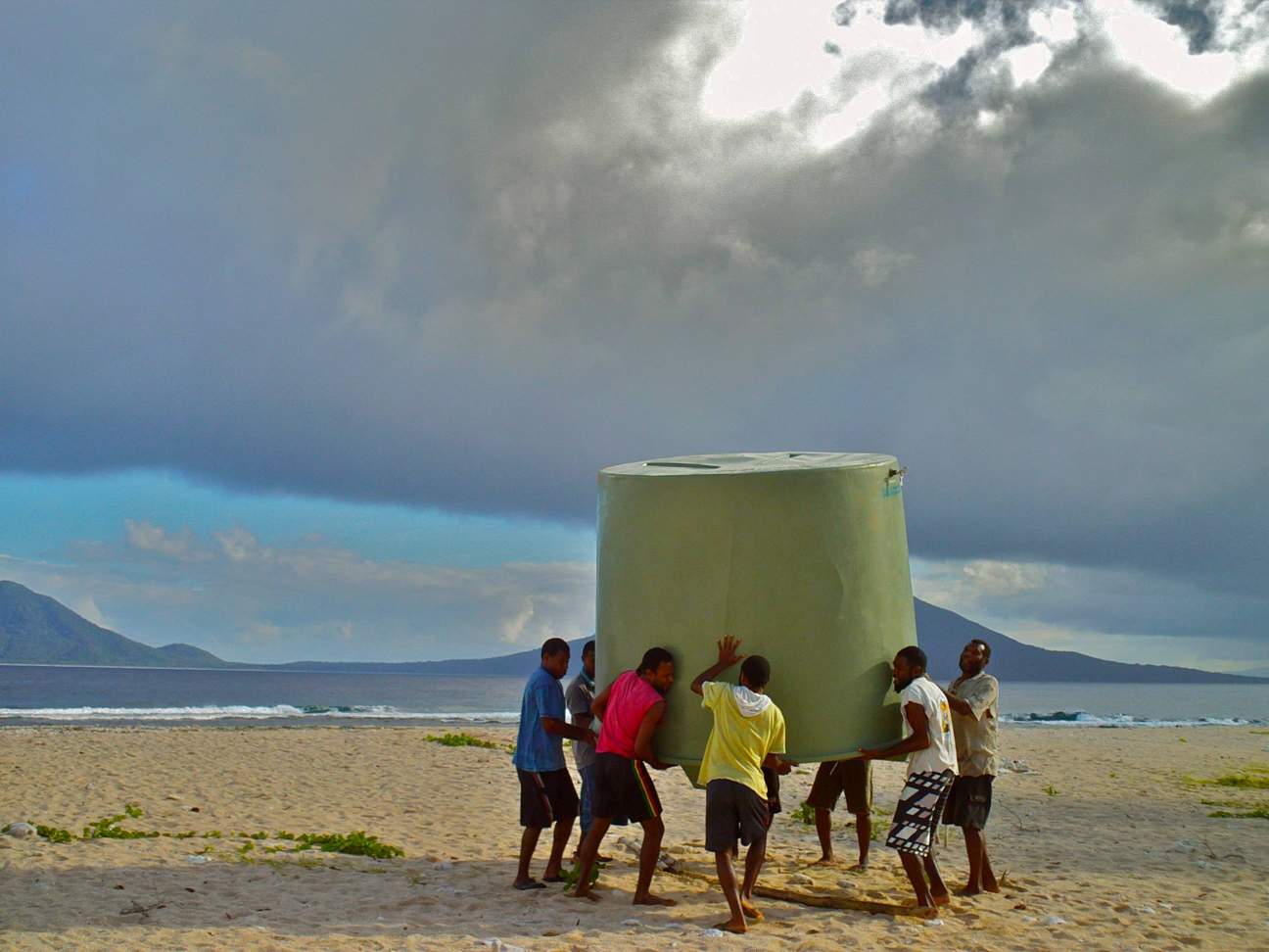 Several people carrying water tank for project in Republic of Vanuatu