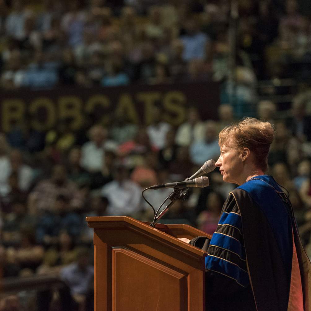 President Denise M Trauth addresses graduation candidates at a Spring 2016 Texas State University commencement ceremony.