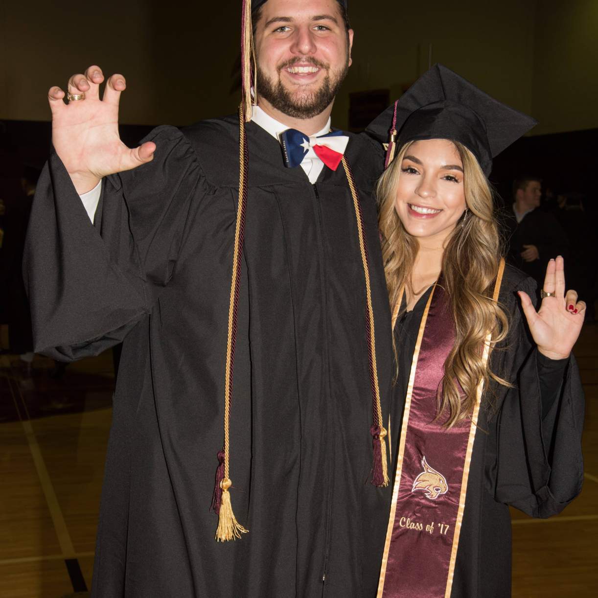 Graduates doing the Texas State hand signs before the ceremony.