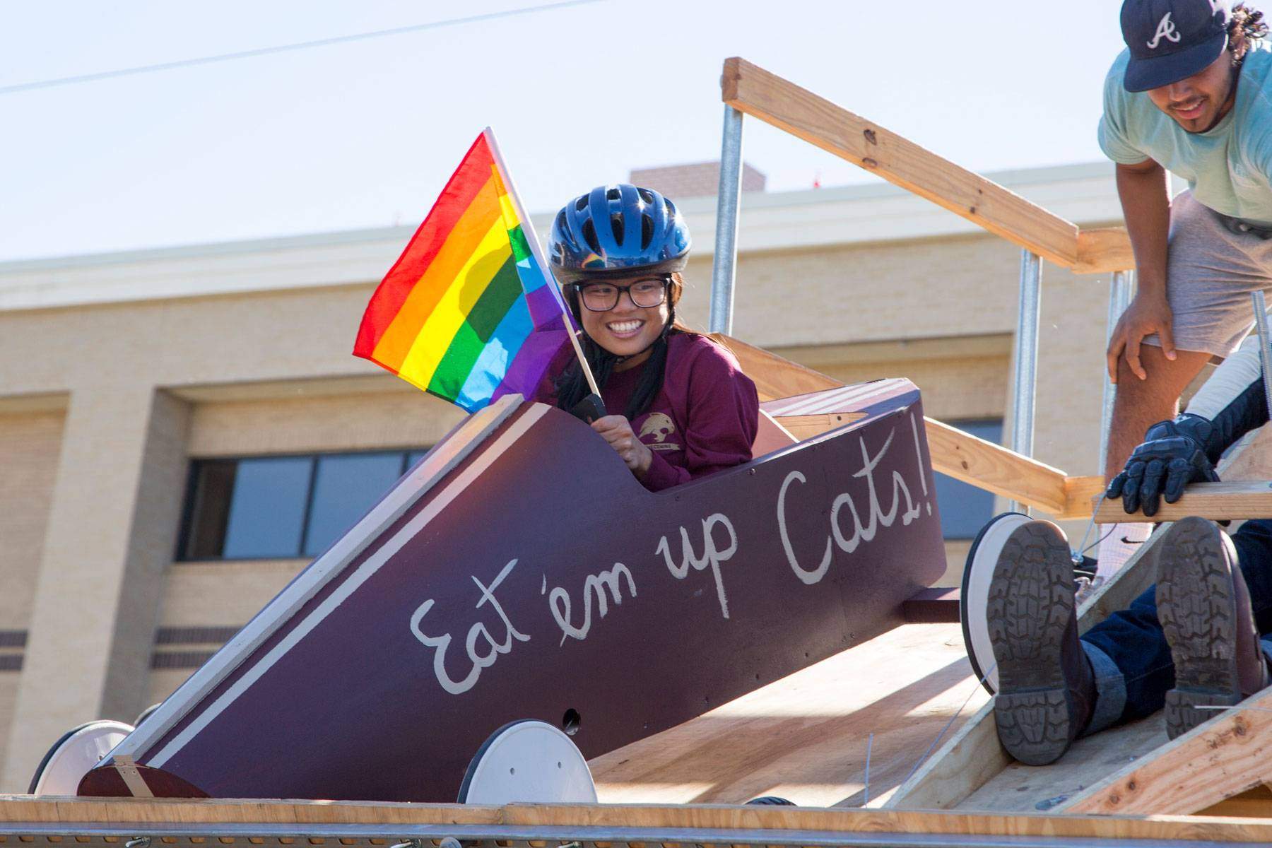 soap box derby contestant holding a pride flag