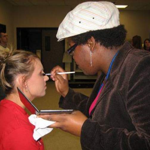 Model having makeup applied before the Fashion Merchandising Fashion Show 2006.