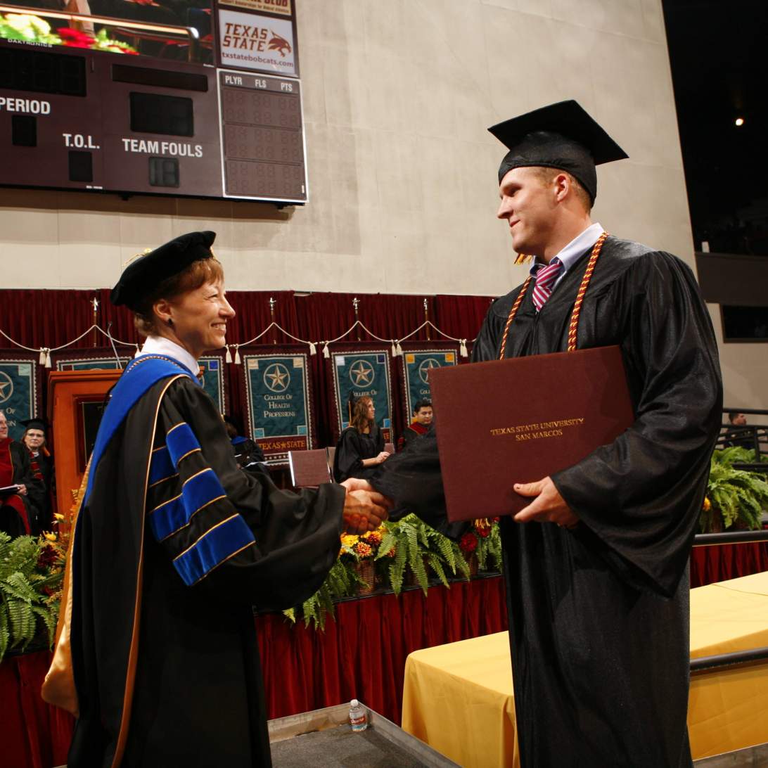 Graduating senior shaking hands with President Trauth 