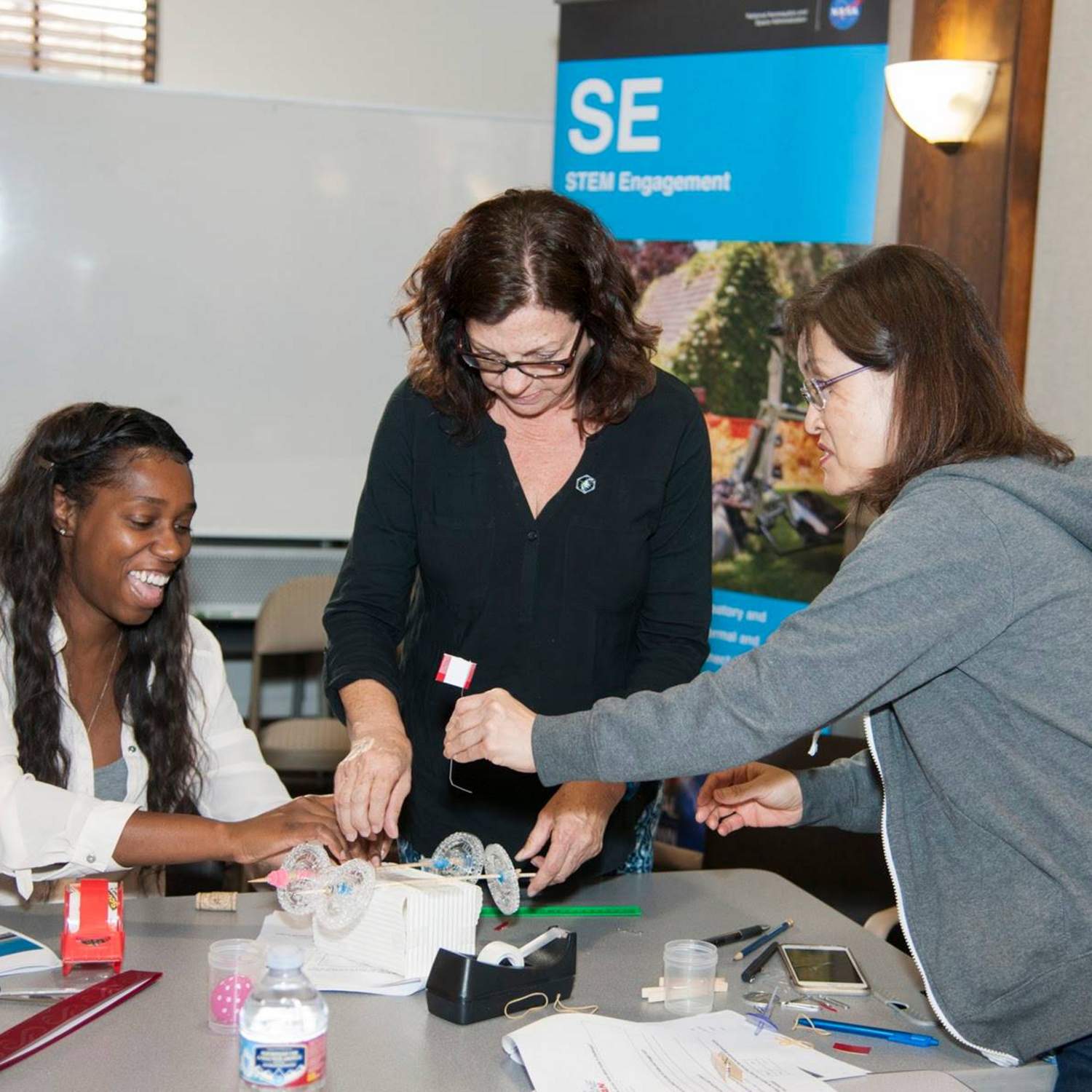 three female faculty members participating in STEM activity