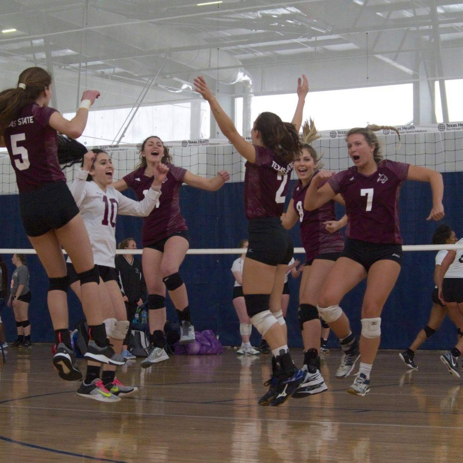 Women's Volleyball club celebrates on court