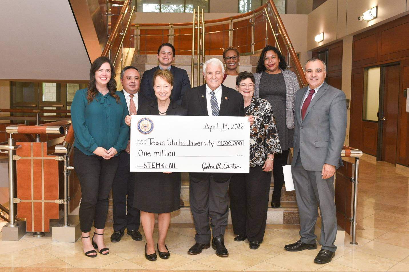 group of people smiling with big check