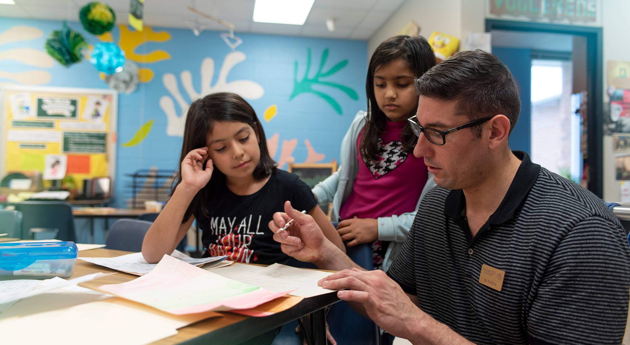 male teacher working with two young girls