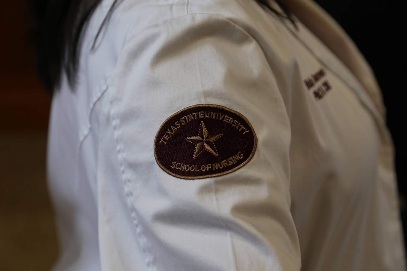 School of Nursing arm patch on white lab coat