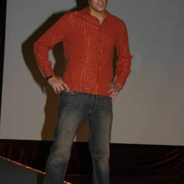 Student wearing red striped shirt, jeans, and loafers