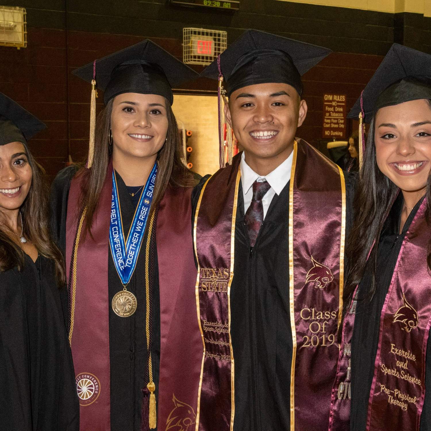 Four graduates smiling 