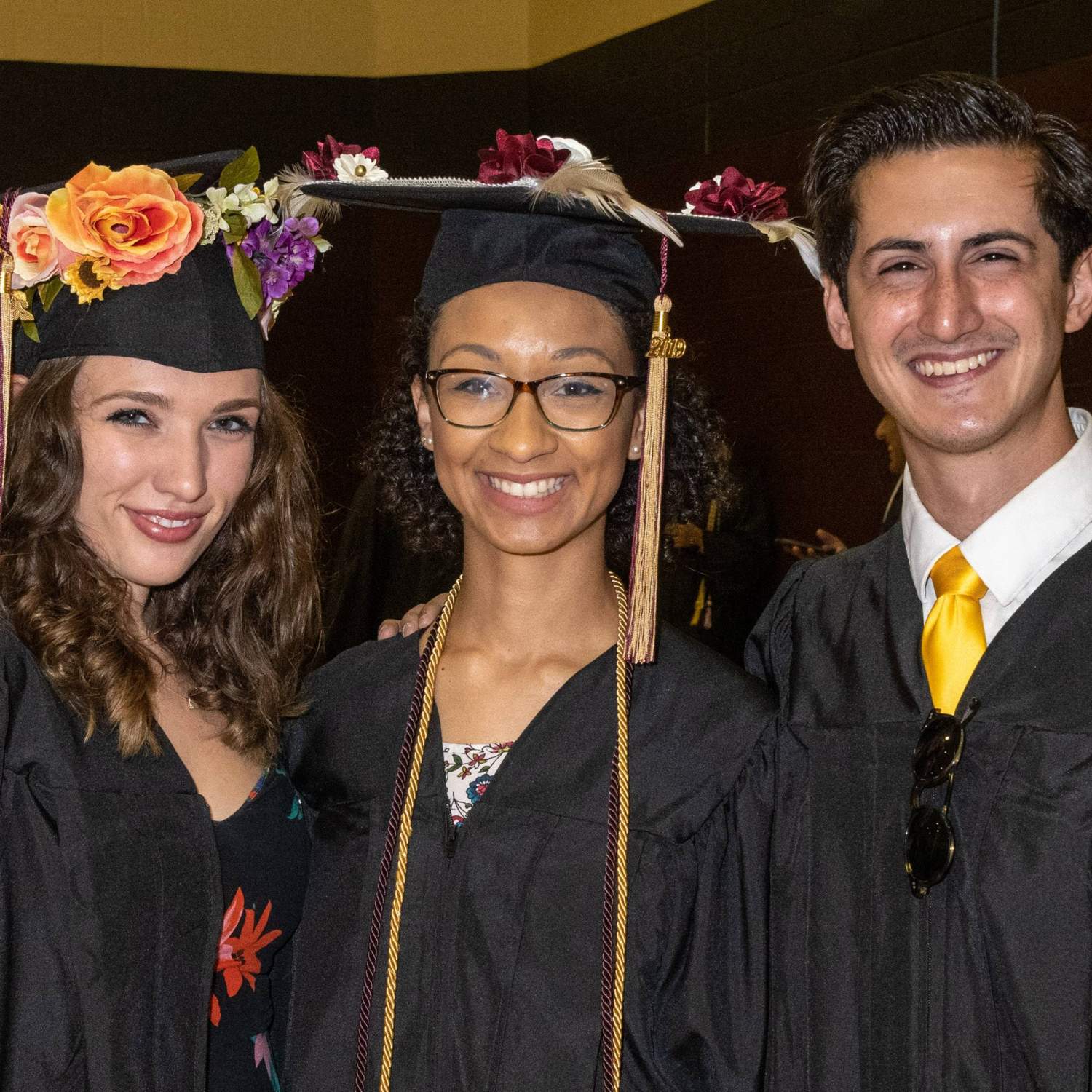 Three graduates smiling 