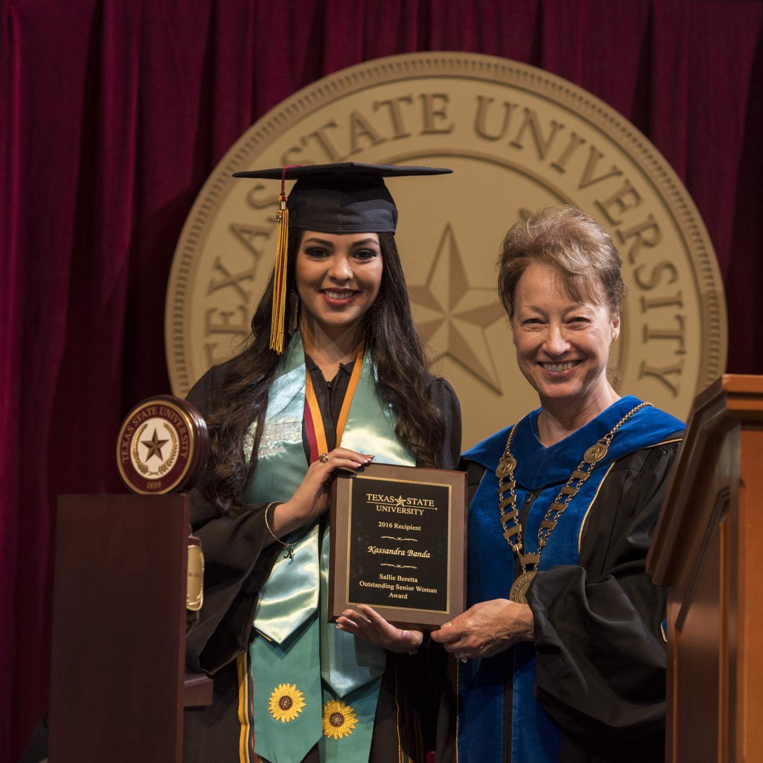 Ms. Kassandra Banda receives the Sallie Beretta Outstanding Senior Woman Award from President Trauth at a Spring 2016 Texas State University commencement ceremony.