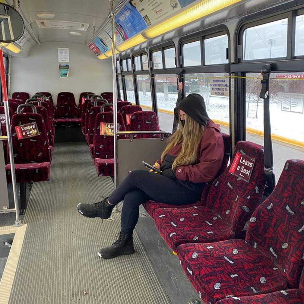female student sitting on shuttle bus