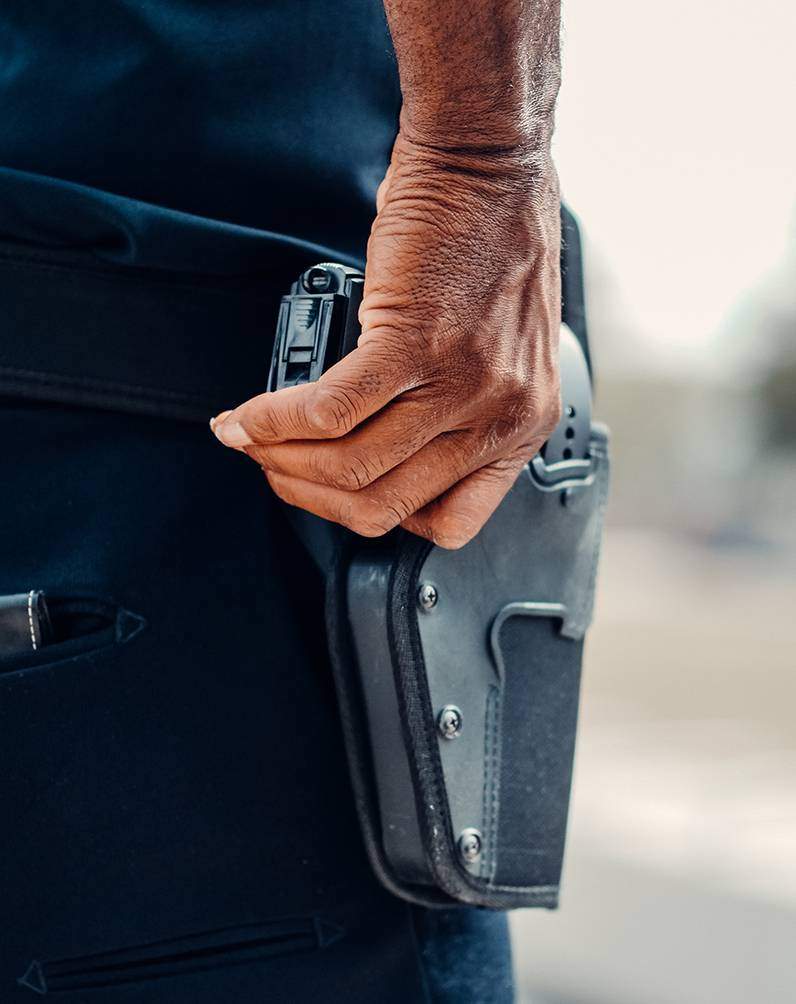 police officer resting hand on gun holster