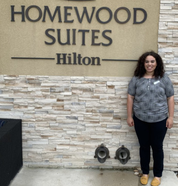 Jordan standing in front of a Homewood Suites sign 