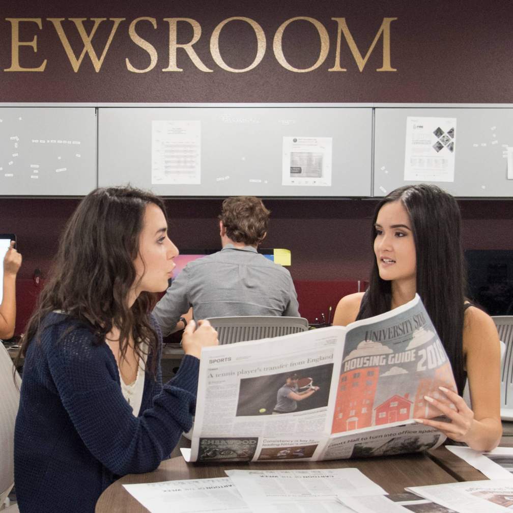Brooke and a classmate discuss a newspaper proof
