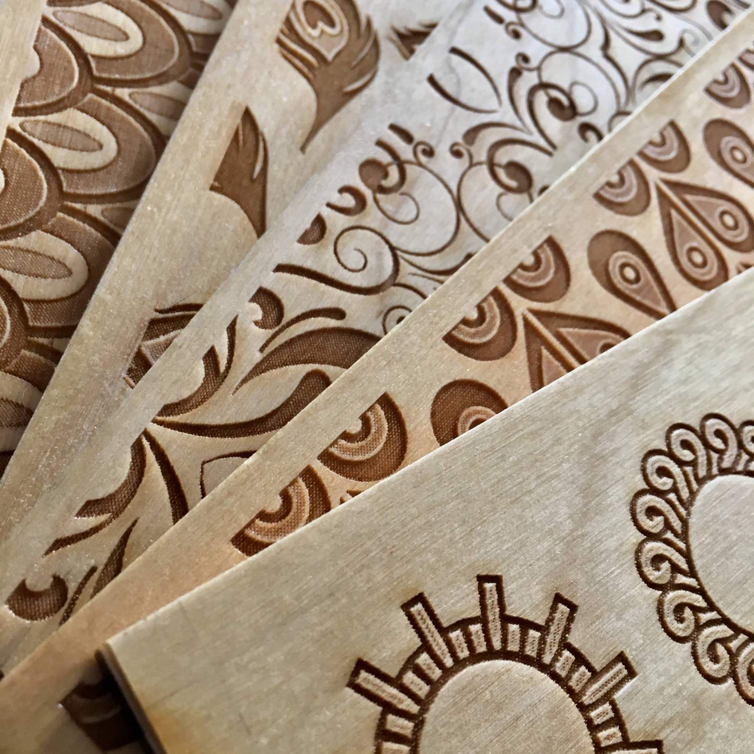 Close up of designs laser engraved on pieces of wood