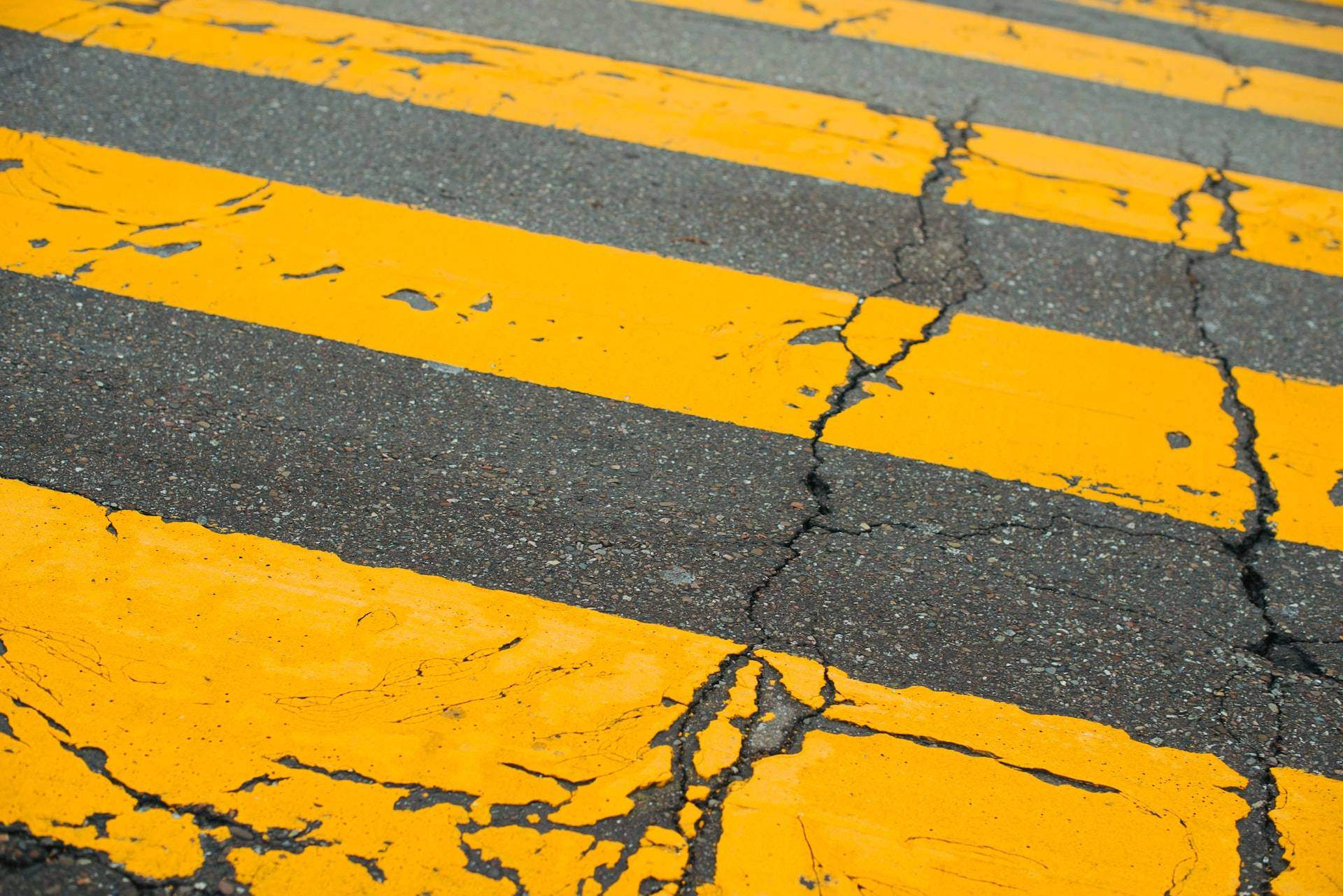 cracks in yellow and black pavement