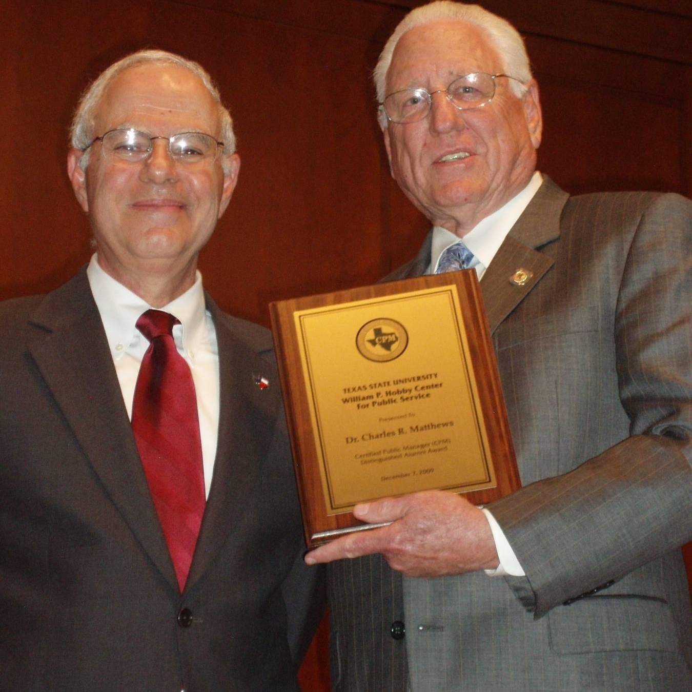 Howard Balanoff presents the CPM Distinguished Alumni Award to Texas State University Chancellor Charles Matthews (right).