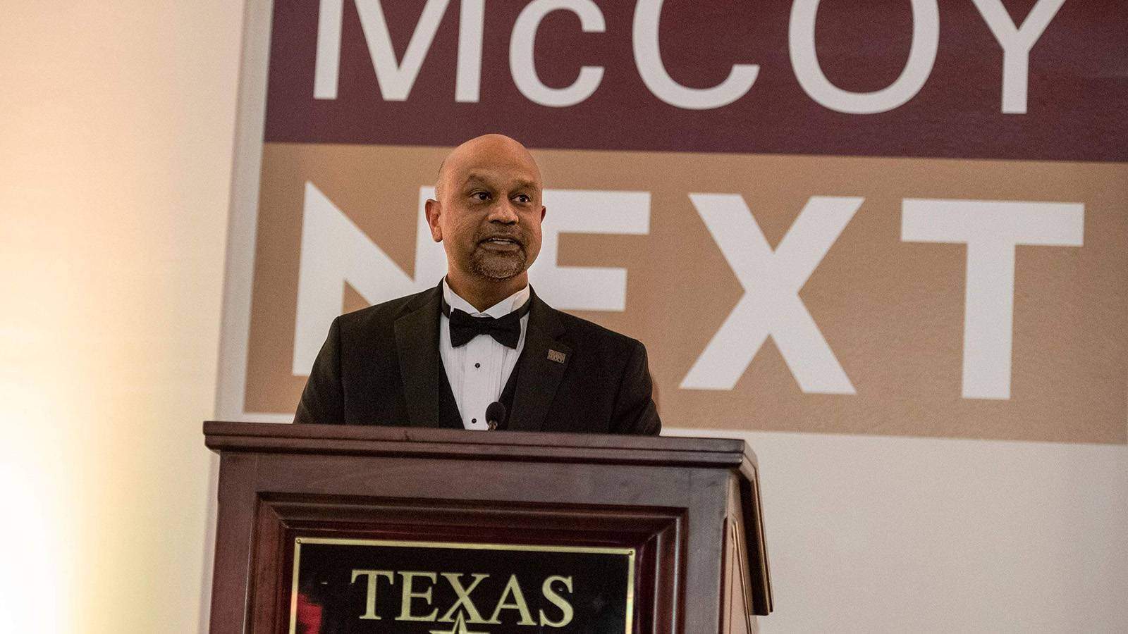 McCoy College Dean Sanjay Ramchander in a tuxedo speaking at a podium at the McCoy Next Gala in March 2022
