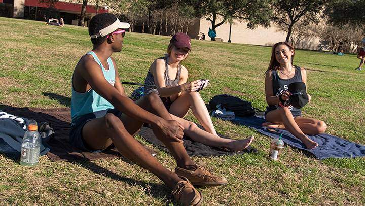 students sit on the hill at sewell park
