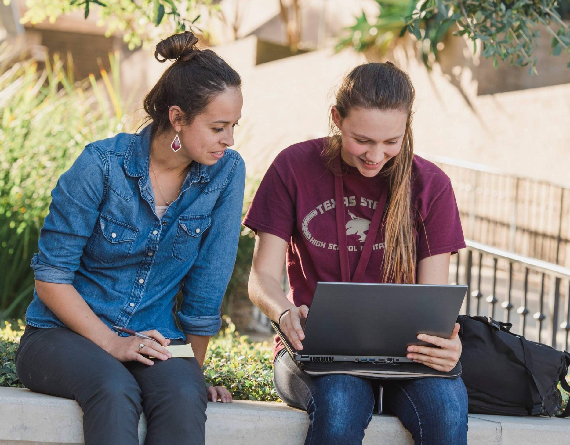 Students Studying Outside. Both students are looking at one laptop.