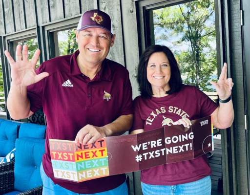 kelly and beth damhousse holding txst welcome banner