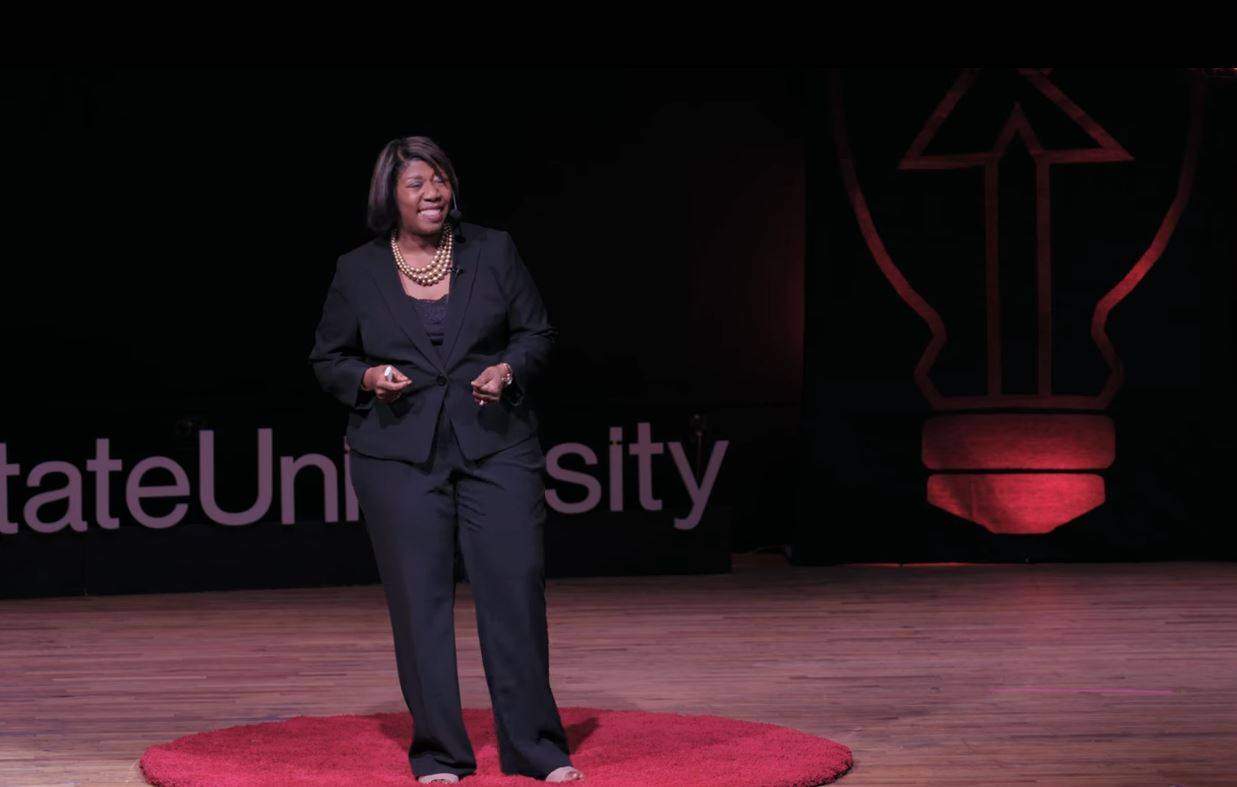 Dr. Ashford-Hanserd on stage giving a ted talk