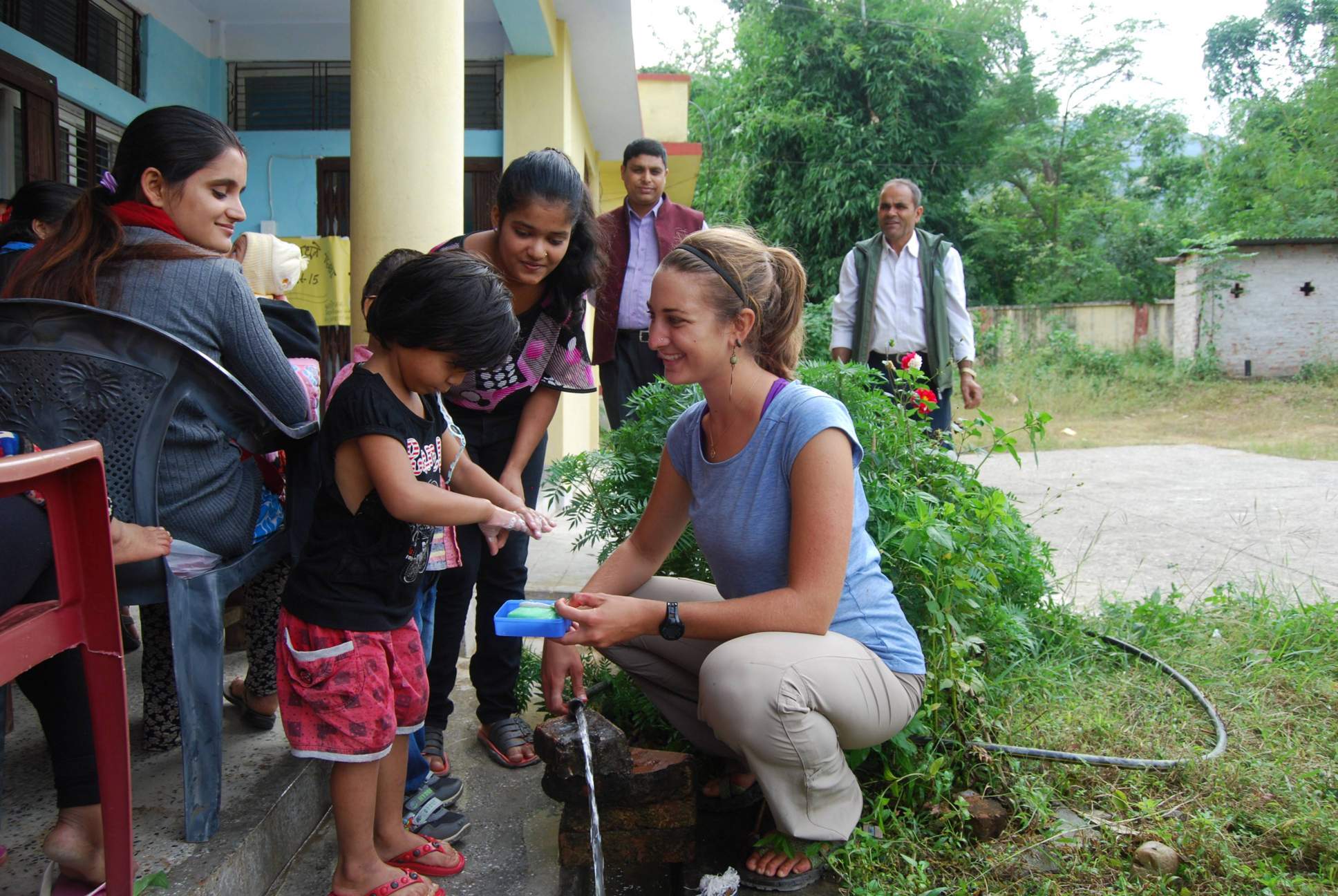 Peace Corps Volunteer helping child wash hands in Nepal