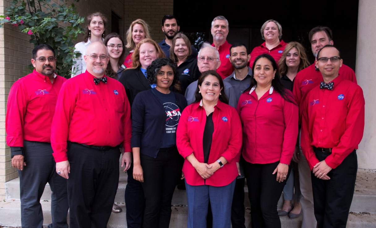 Group photo of faculty and staff int NASA program wearing red long sleeved shirts with NASA logo over front left-side of shirt 