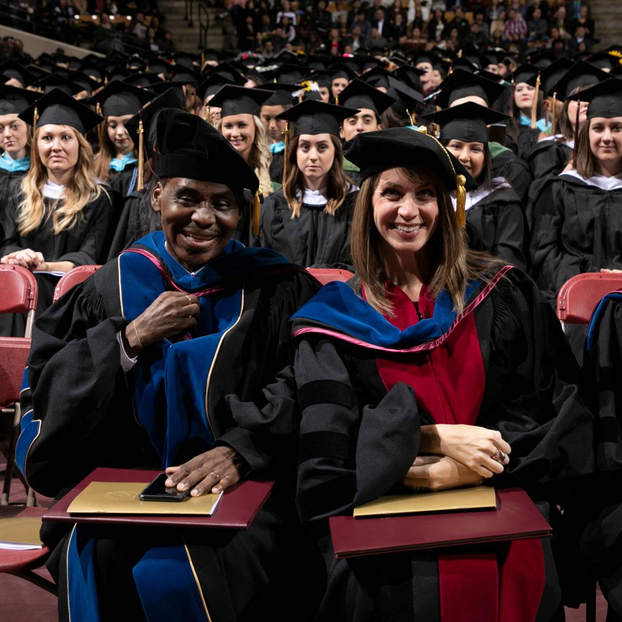 Doctoral graduates seated on floor