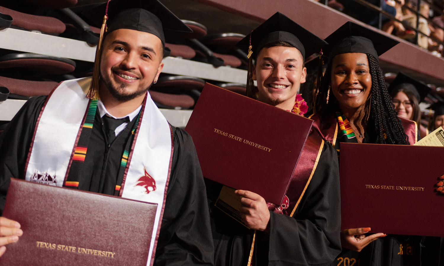Graduating students holding diplomas