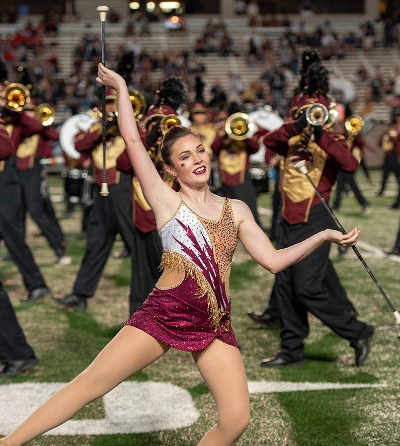 woman twirling baton during marching band routine