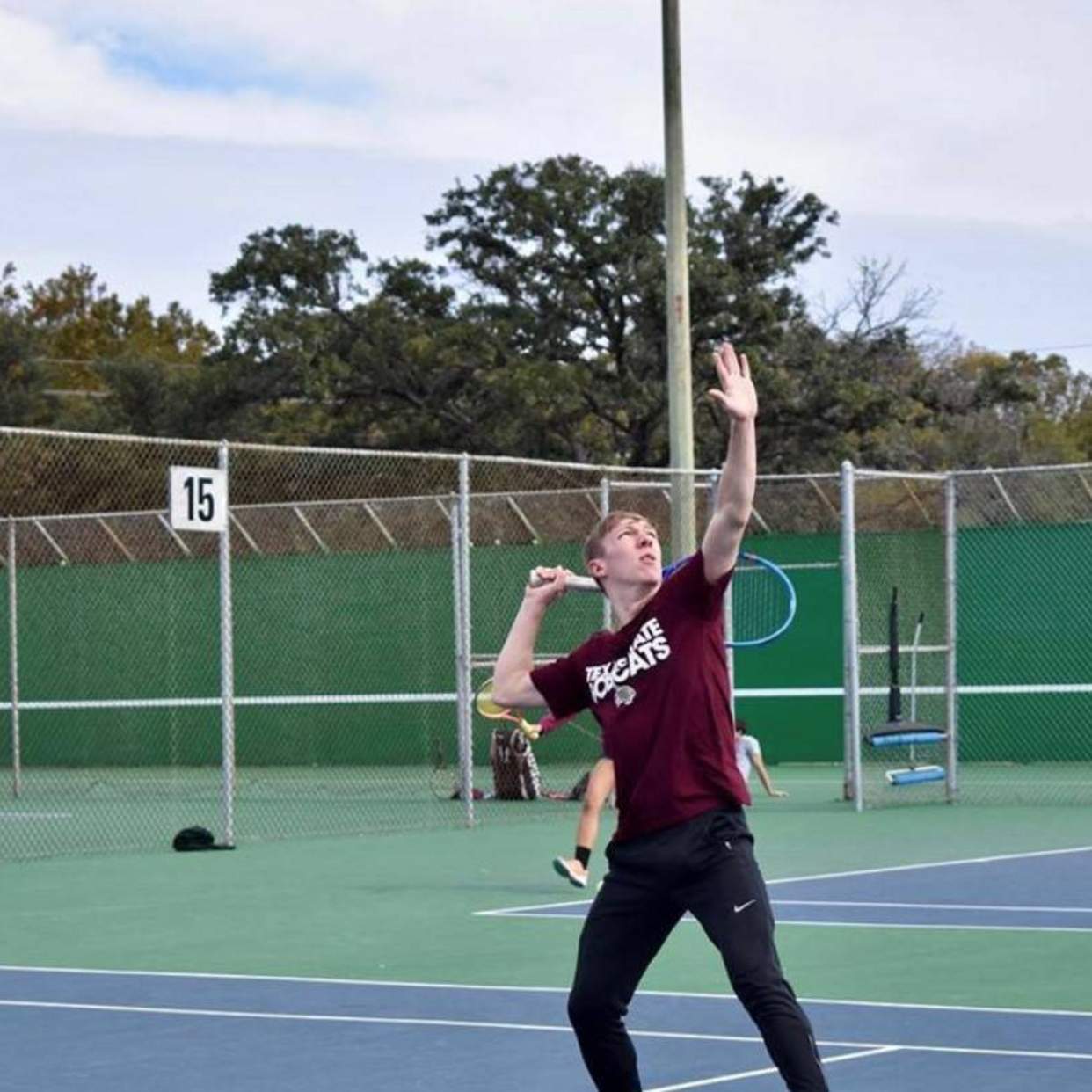 Tennis player prepares to return overhead