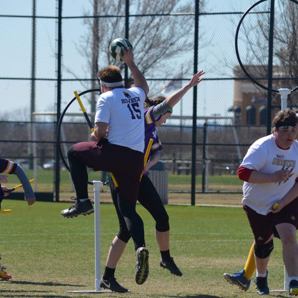 Quidditch player attempts a shot while jumping while being defended