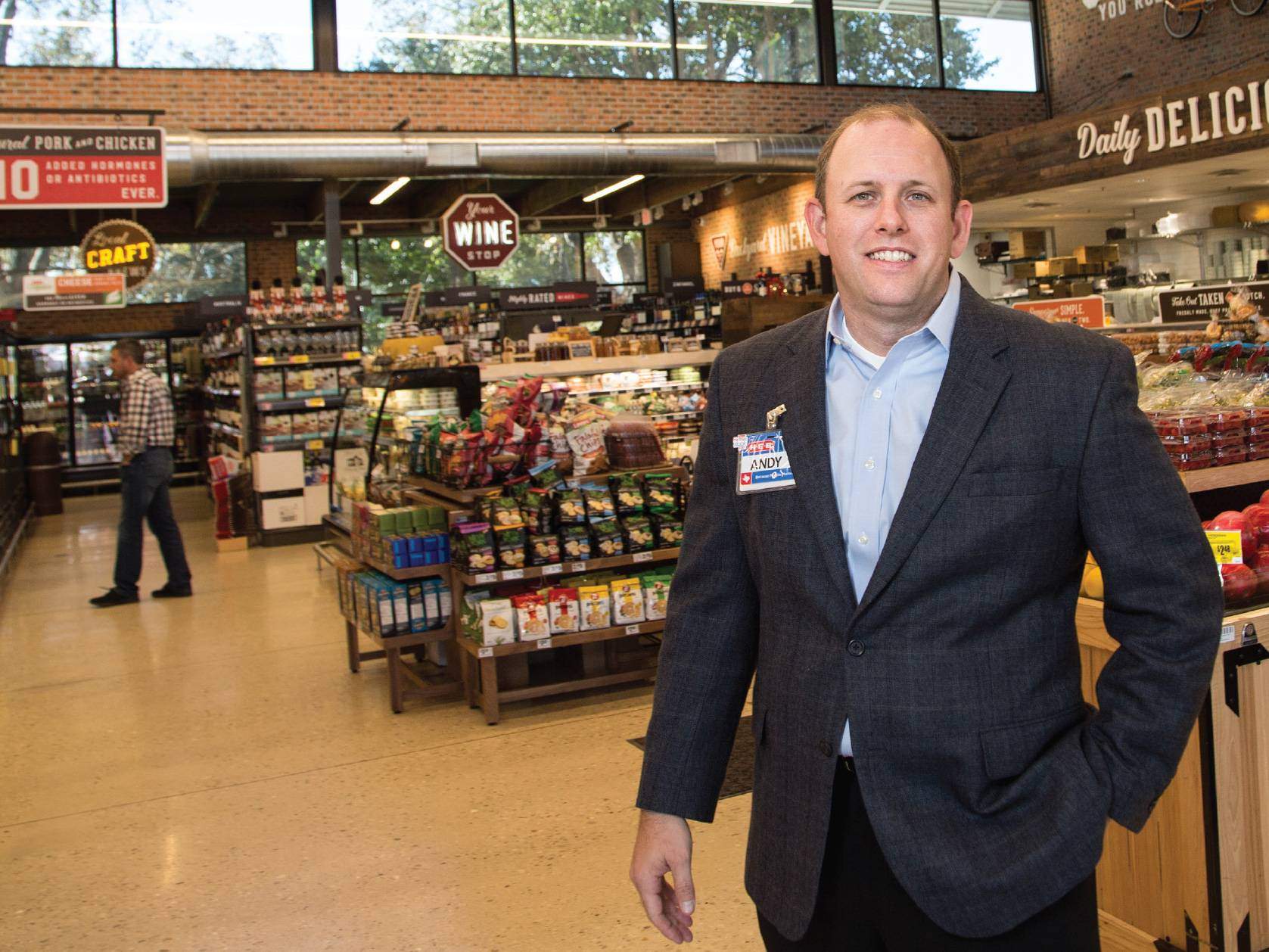Man stands in HEB grocery wearing nametag